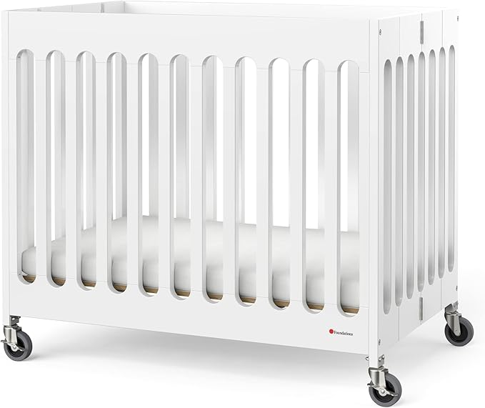 Foundations Boutique Folding Mini Baby Crib - Compact, Portable, Wooden Hotel Crib, Foldable Mini Crib for Baby & Toddlers - Includes 3" Foam Mattress, White