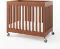 Foundations Boutique Folding Mini Baby Crib - Compact, Portable, Wooden Hotel Crib, Foldable Mini Crib for Baby & Toddlers - Includes 3" Foam Mattress, Cherry