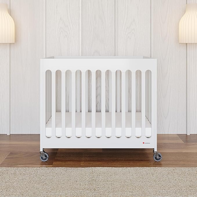 Foundations Boutique Folding Mini Baby Crib - Compact, Portable, Wooden Hotel Crib, Foldable Mini Crib for Baby & Toddlers - Includes 3" Foam Mattress, White